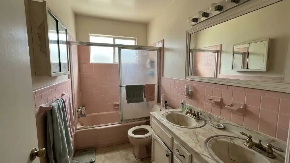 2-BATHROOM-REMODEL-BEFORE-LOSANGELES outdated bathroom with pink tiles and double sink vanity