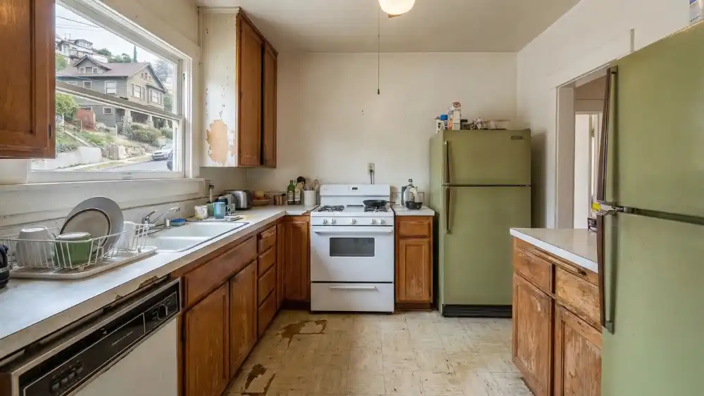 2-KITCHEN-REMODEL-BEFORE-LOSANGELES Old kitchen interior before renovation with worn cabinets and appliances